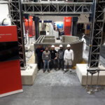 Mitarbeiter vor fertigem Haus auf der Bautec 2020