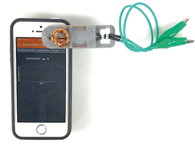 Smartphone mit Clip und Spule dran
