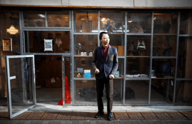 Okawara mit einer Frauenmaske