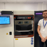 Mitarbeiter von Additech vor einem 3D-Drucker