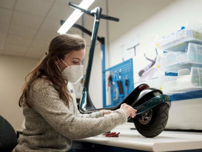 Frau arbeitet an E-Scooter Scotsman