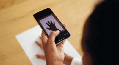 Hand auf DIN-A4-Blatt wird fotografiert
