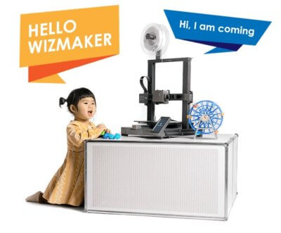 Kind sitzt vor 3D-Drucker und begrüßt ihn, 3D-Drucker antwortet