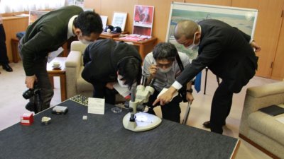 Vier Personen neben Mikroskop