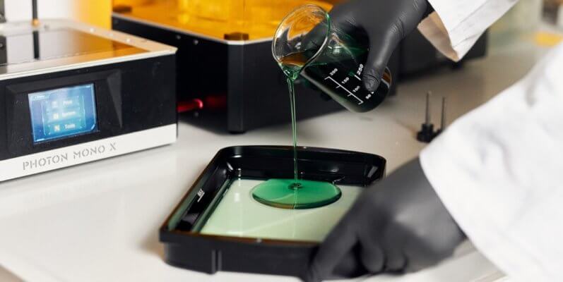 Mitarbeiter gießt Harz in Wanne