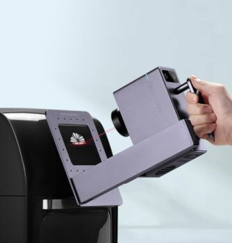 Lasergravierer wird leicht angewinkelt an Objekt gehalten