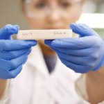 Frau hält weißes Objekt mit Aufschrift Silica 3 und Silica 8 hoch