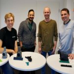 Team von MakerVerse und 3D-gedruckte Teile auf kleinen Tischen