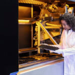 Frau steht vor Maschine