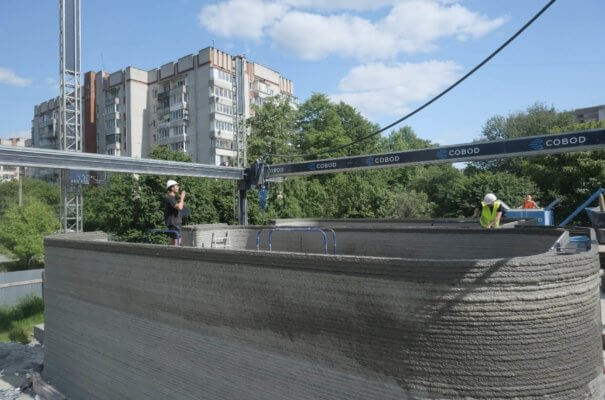Mitarbeiter auf dem Gebäude während des 3D-Drucks der letzten Schichten