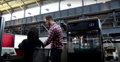 Mitarbeiter in Werkstatt neben 3D-Drucker