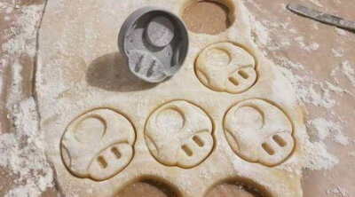 Keksausstecher auf ausgerolltem Teig mit bereits ausgestochenen Formen