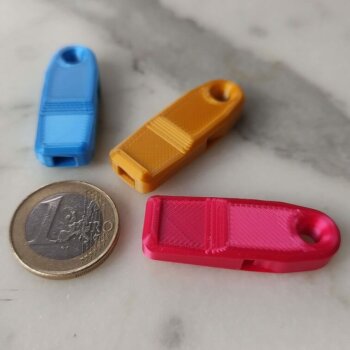 Drei 3D-druckbare Hundepfeifen neben einer 1 Euro Münze
