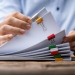 Geschäftsmann blättert durch Akten im Zusammenhang mit 3D Systems und Stratasys-Angeboten