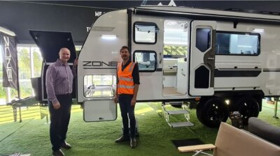 ZoneRV-Mitarbeiter vor einem Wohnmobil ZoneRV-Team vor einem mit 3D-Drucktechnologie gefertigten Wohnmobil.