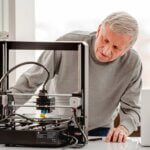 Person vor 3D-Drucker bei den ersten Schritten im 3D-Druck