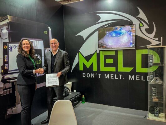 Handschlag zwischen Fooke und Meld Manufacturing Vertretern zur Bekanntgabe der Metall-3D-Drucktechnologie Integration auf der Formnext 2023