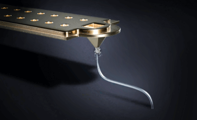 Exaddons präziser Mikro-3D-Druckprozess für Halbleitertests dargestellt durch leuchtende Miniatur-Eiffeltürme Computergenerierte Darstellung von Exaddons 3D-Drucktechnologie mit zwei Zentimeter großen Eiffeltürmen, leuchtend unter UV-Licht