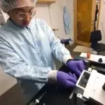 PhD-Student Lee-Lun Lai beim Laden eines Tabletts in einen 3D-Mikrodrucker für die nachhaltige Produktion von Polymertransistoren