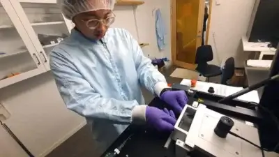 PhD-Student verwendet 3D-Mikrodrucker zur Herstellung von Polymertransistoren am KTH Royal Institute of Technology PhD-Student Lee-Lun Lai beim Laden eines Tabletts in einen 3D-Mikrodrucker für die nachhaltige Produktion von Polymertransistoren