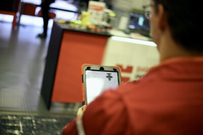 Techniker von Würth Additive Group zeigt DIS Global auf AMUG Expo Würth Additive Group Mitarbeiter präsentiert DIS Global Plattform auf Tablet bei AMUG Expo