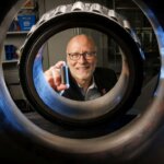 Joe Turner mit 3D-gedrucktem Eisenbahnrollenlager durch echtes Lagergehäuse fotografiert - Nebraska Engineering Innovation