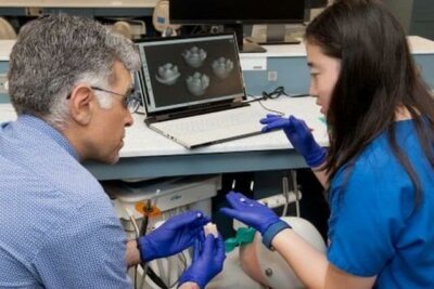 Dozent der Midwestern University erklärt Zahnmedizinstudentin die digitale Gestaltung von Prothesen am Laptop mit 3D-Drucktechnologie.