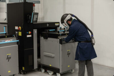 Mitarbeiter von Endeavor 3D beim Einsatz eines Metall-3D-Druckers nach ITAR-Standards Mitarbeiter von Endeavor 3D bedient Metall-3D-Drucker zur Fertigung nach ITAR-Standards