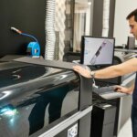 Ein Techniker arbeitet am Stratasys H350 3D-Drucker, der SAF Polypropylen zur Herstellung chemikalienbeständiger Bauteile verwendet