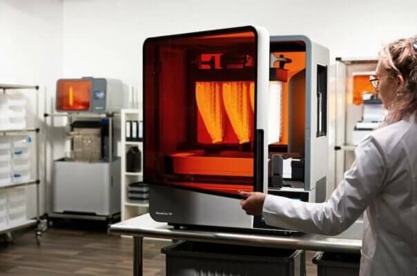 Formlabs Form 4L 3D-Drucker mit großer Baufläche und Drittmaterial-Support Technikerin arbeitet mit dem Formlabs Form 4L 3D-Drucker, großformatiges Drucksystem für Drittmaterialien