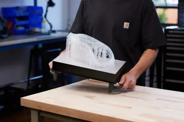 Großformatiges SLA-Objekt aus dem Formlabs Form 4L 3D-Drucker Mitarbeiter hält eine große 3D-gedruckte Komponente, die mit dem Formlabs Form 4L SLA-Drucker erstellt wurde