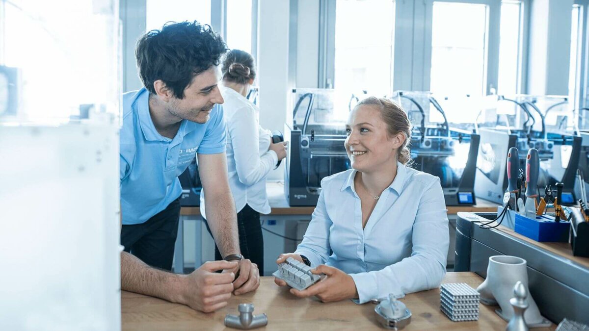 Zwei Forward AM Mitarbeiter arbeiten an 3D-Druck-Bauteilen in einem Labor