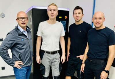 Das Team von HENNgineered mit dem 3D-Drucker Lumia X1 und der innovativen HPS-Technologie. HENNgineered-Team vor dem 3D-Drucker Lumia X1 von Axtra3D, der die Produktionsgeschwindigkeit und Präzision durch HPS-Technologie verbessert.