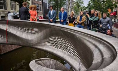 3D-gedruckte Metallbrücke von MX3D, eröffnet von Königin Máxima, mit Beteiligten und Zuschauern in Amsterdam