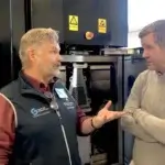 Ein Gespräch zwischen Professor Lars-Erik Rännar von der Mid Sweden University und einem Sandvik-Vertreter vor einer EBM-Maschine, die für gemeinsame Forschungsprojekte genutzt wird.