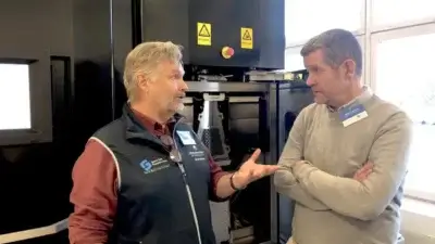 Professor Lars-Erik Rännar und Sandvik-Vertreter besprechen Forschungsprojekte zur Entwicklung neuer EBM-Metallpulver. Ein Gespräch zwischen Professor Lars-Erik Rännar von der Mid Sweden University und einem Sandvik-Vertreter vor einer EBM-Maschine, die für gemeinsame Forschungsprojekte genutzt wird.