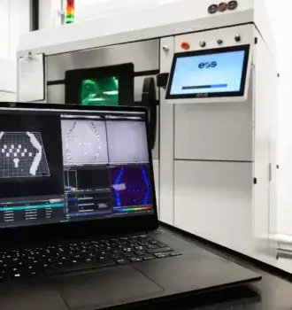 EOS-Maschine mit AM Explorer für Qualitätsüberwachung im 3D-Druck Laptop mit AM Explorer-Software vor einer EOS-3D-Druck-Maschine zur Prozessüberwachung und Datenvisualisierung