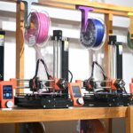 Mehrere Prusa Mini 3D-Drucker in der Esplora-Ausstellung, die den 3D-Druckprozess mit nachhaltigem PLA-Filament aus recyceltem Plastik zeigen