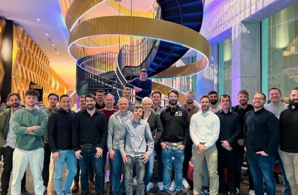 Teilnehmer des Netzwerktreffens für 3D-Druck-Dienstleister während der Formnext 2024, vor einer modernen Architekturkulisse.