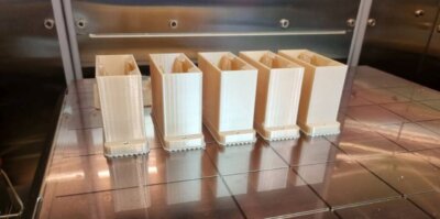 3D-gedruckte Polymer-Bauteile von Airframe Designs für Luftfahrtanwendungen. Mehrere 3D-gedruckte Bauteile aus Polymer auf einer Druckerplattform, gefertigt von Airframe Designs für die Luftfahrt.