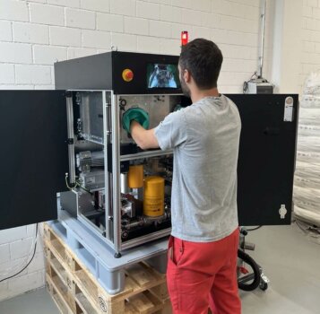 Kompakter L-PBF-Metall-3D-Drucker von a-metal mit innovativem Pulverpatronensystem Mitarbeiter bedient den kompakten Metall-3D-Drucker von a-metal, der Pulverpatronen für mehr Sicherheit und Benutzerfreundlichkeit verwendet