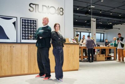 Innenansicht des PUMA Studio48 mit Personen bei der Arbeit, Holzschränken und modernem Design