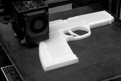 Symbolfoto einer 3D-gedruckten Waffe, passend zur Diskussion um Geisterwaffen im Mordfall eines US-Versicherungschefs. 3D-gedruckte Waffe auf einem Druckbett, thematisch zur Debatte um Geisterwaffen und 3D-Druck-Technologie im Mordfall eines Versicherungschefs.