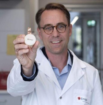 Empa-Forscher Gustav Nyström mit einer biologisch abbaubaren Pilzbatterie. Empa-Forscher Gustav Nyström hält eine Pilzbatterie in einer Bienenwachskapsel, die im 3D-Druck hergestellt wurde.