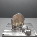 Prototypen einer Radiusplatte und eines Hüftimplantats aus Titan, gefertigt mit der DED-LB/M-Technologie des ATILA-Projekts zur Optimierung der Materialausnutzung.