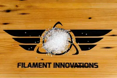 Filament Innovations Logo auf Holz mit transparenten Kunststoffpellets für den 3D-Druck