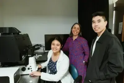 Drei Forschende der Rice University in einem Labor, während sie an einem Mikroskop arbeiten und neue lebende Materialien für 3D-Druck und Medizin erforschen