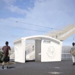 Rendering des ersten 3D-gedruckten Bahnhofs in Japan, Hatsushima-Station in Wakayama, mit modernem, weißem Betonbau und Fußgängerbrücke
