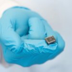 Nahaufnahme eines 3D-gedruckten weichen Aktors, gehalten von einer Person mit blauen Handschuhen, entwickelt für Anwendungen in der Robotik und Medizin