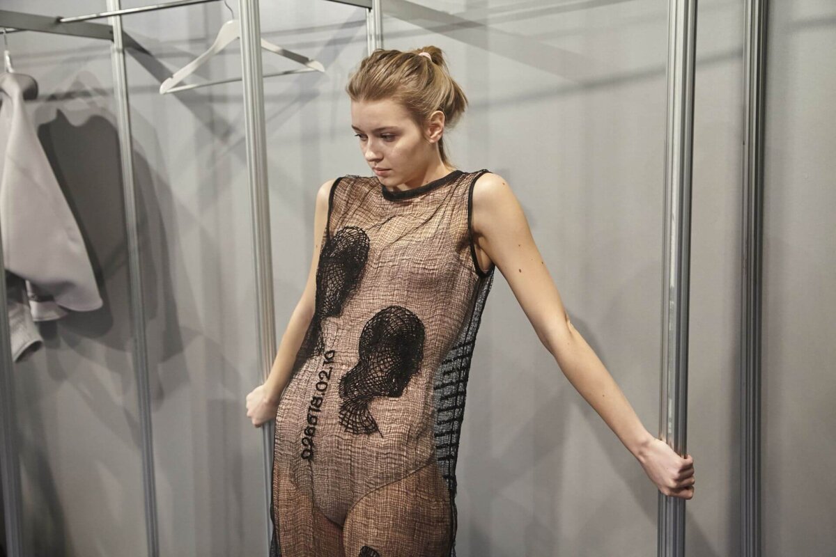 Model trägt ein futuristisches Kleid aus 3D-gedrucktem Stoff von ZER Collection, entwickelt mit innovativer Fertigungstechnologie